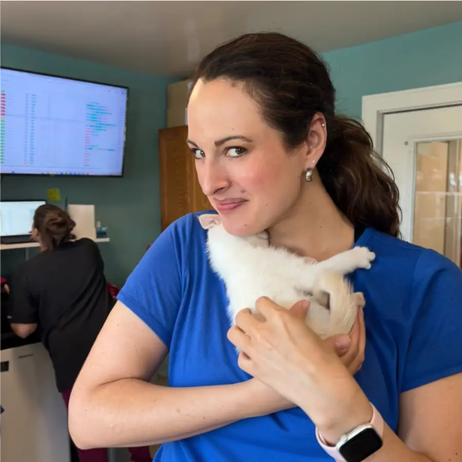Brooke Bernard holding a cat while ClinicDay runs in the clinic background